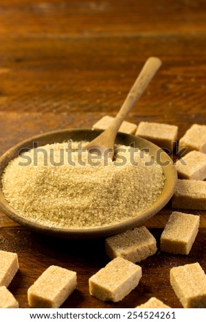 brown sugar in a wooden bowl with sugar cubes