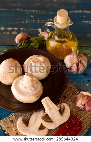 fresh mushroom with garlic,oil,pepper on a blue wooden table