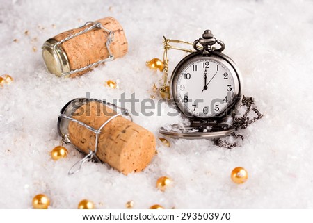 new year\'s eve concept with champagne cork and a pocket watch showing twelve o\'clock