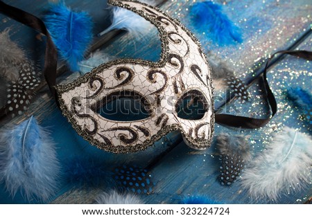 female carnival mask with blue glittering background