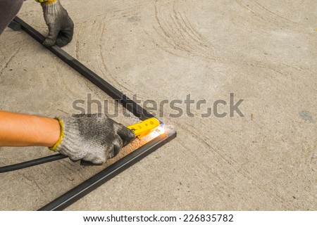 Workers are welding two pieces together on the cement floor