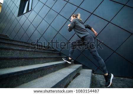 Female athlete running fast up the stairs - staircase workout
