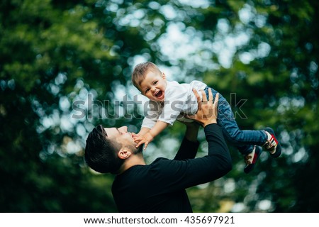 happy joyful father having fun throws up in the air his small child, family, father's day - concept.