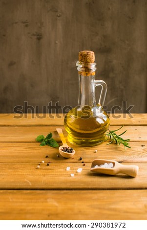 Salt, pepper, olive oil, rosemary on a wooden table
