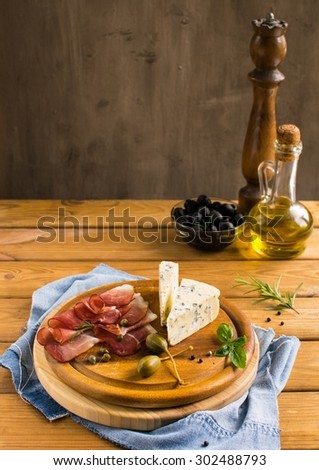 spanish antipasti on  a cutting board on a wooden table