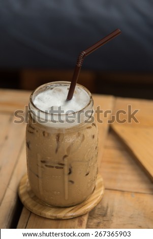 fresh iced coffee and delicious chocolate crape cake serve on wooden tray in coffee shop