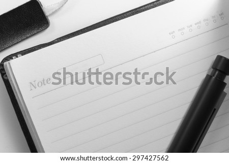 black and white tone for  sad emotion , paper with line and date inside of notebook and pen