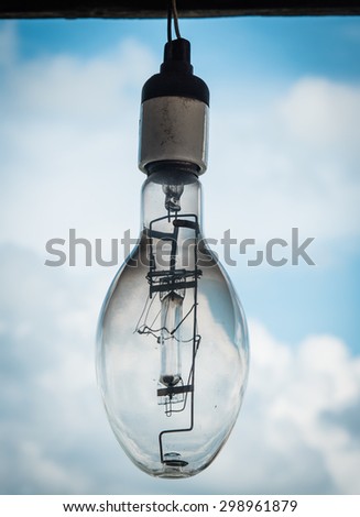 vintage photo style of old retro light bulb in not use condition with sky background