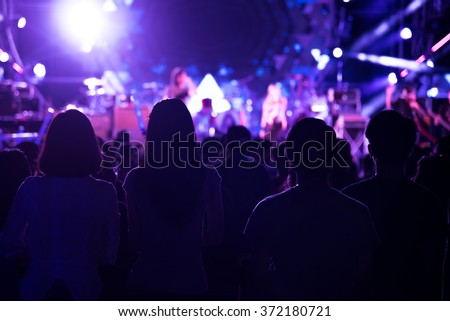 blured background of funny people in very fun music band performing concert with smoke bomb and paper shooting