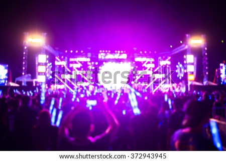 blurred background of funny people in very fun music band performing concert with smoke bomb and paper shooting