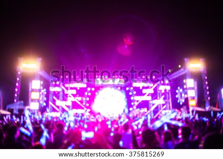 blurred background of funny people in very fun music band performing concert with smoke bomb and paper shooting