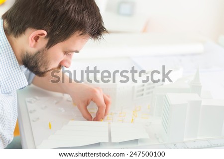Young architect working on a architectural model