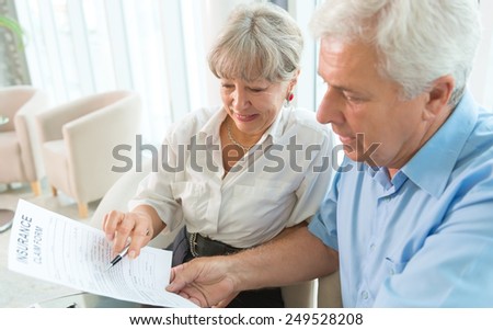Senior couple read the form for life insurance