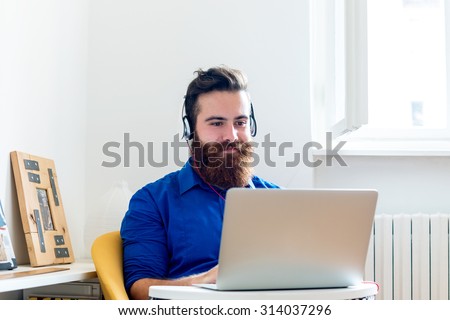 Young Man working on a Computer and listening to Music