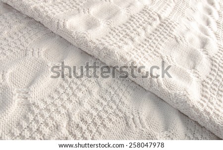 White knitted blanket folded diagonally