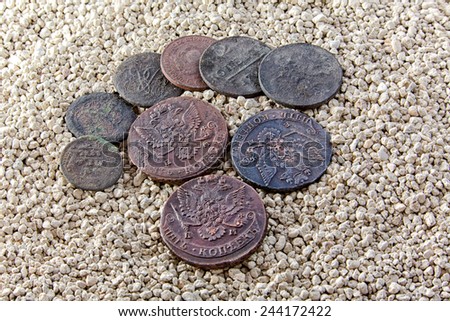 old copper coins on river sand