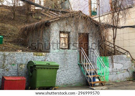 the mysterious small house with a ladder and trash cans on a mountain slope