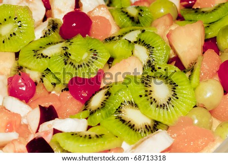 Fruit salad detail with kiwi, cherry, orange, apple and grapes.
