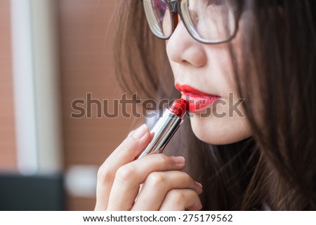 Closeup with perfect skin paints her lips red lipstick