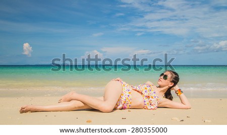 Young Asian woman in bikini enjoying tropical beach
