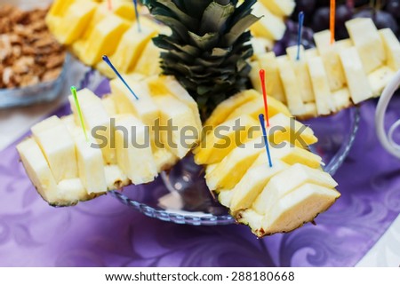 Banquet table served with delicious food. Fresh pineapple on the dish. Fruit dessert