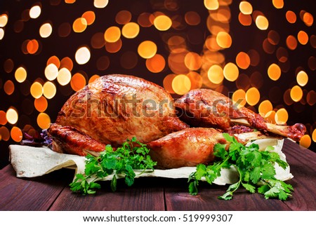 Roasted Turkey. Thanksgiving table served with turkey, decorated with greens and basil on dark wooden background. Homemade roasted chicken. Christmas holiday dinner