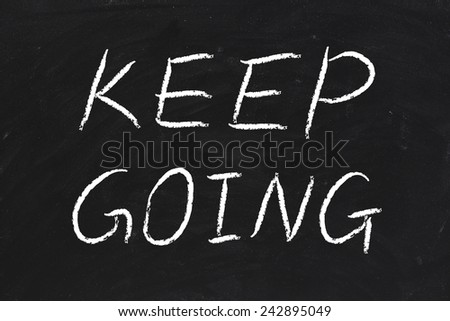 Keep Going text is written by chalk on blackboard.
