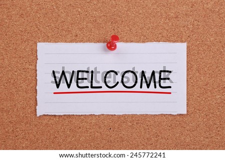 Welcome note paper pinned on cork board.