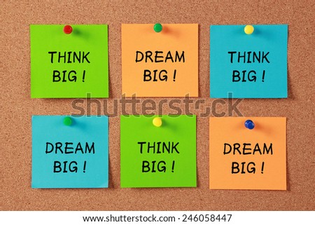 Think Big and Dream Big sticky notes pinned on cork.