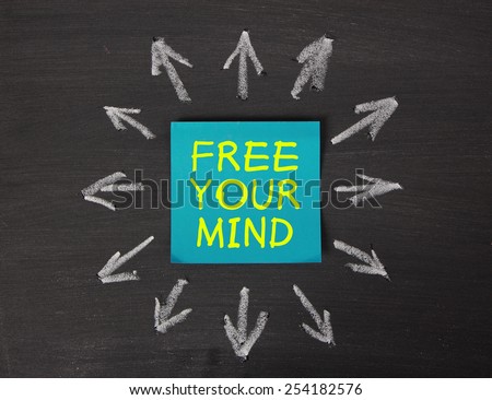 Free Your Mind - relaxation or meditation concept - sticky note pasted on a blackboard background with a lot chalk arrows.
