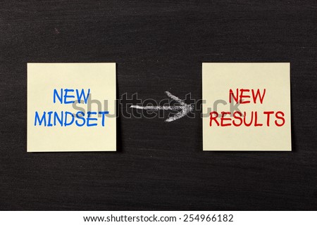 New mindset and new results concept - sticky notes on a blackboard background with a chalk arrow.