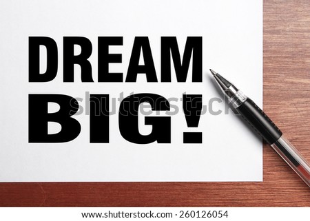 Dream big text is on white paper with black pen aside.