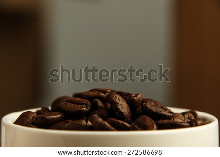 Close up of coffee beans in the coffee cup. Lots of copy space for edit.
