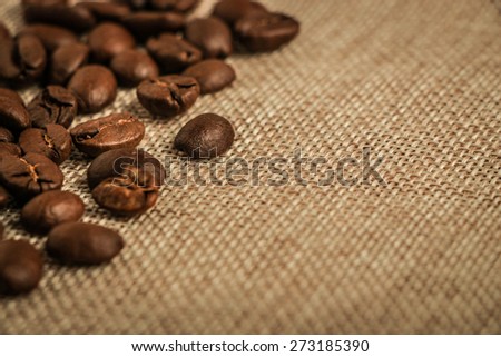 Coffee beans border over burlap sack background. Lots of copy space for edit.