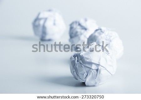 White paper balls are on the blank background.