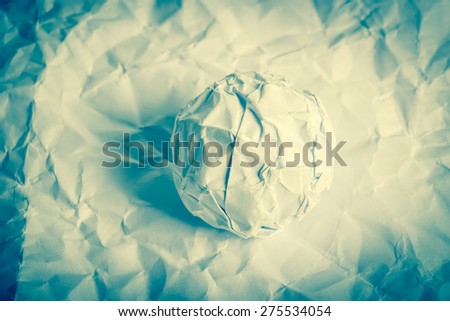 White paper balls are on the wrinkled paper background.