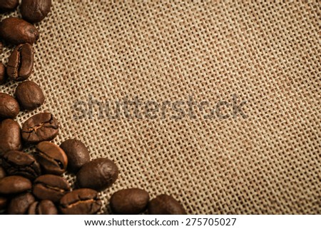 Coffee beans border over burlap sack background. Lots of copy space for edit.