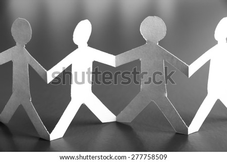 Group of people made of paper are holding hands together. Team concept.