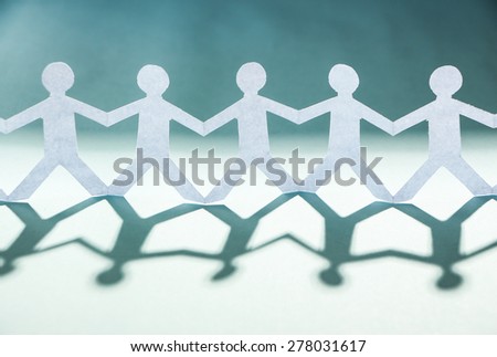 Group of people made of paper are holding hands together. Team concept.