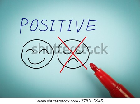 Positive thinking concept is on blue paper with a red marker aside.