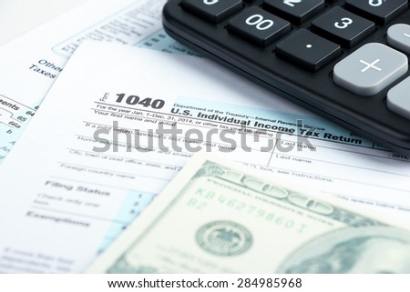 Tax form financial concept with money and some other business objects aside.