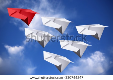 Red paper plane leading white ones in the sky.