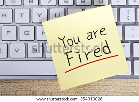 Top view of You Are Fired sticky note pasted on the keyboard.