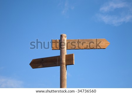 An opposite wood arrows on a post sign