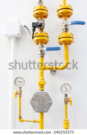 Yellow gas meter against white wall