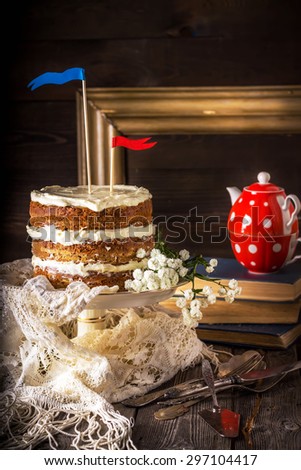 Naked Layer Cake , teapot, vintage tableware and books on wooden table. Style rustic, selective focus.