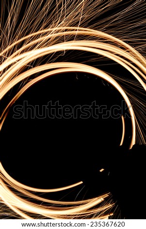 Arcs of fire caused by spinning steel wool on fire.