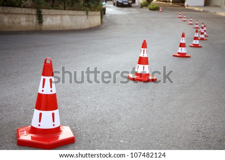 An image of caution cone sign on asphalt road.