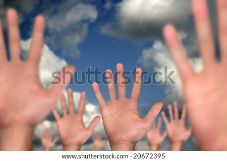 single hand in front of several hands on cloudy background