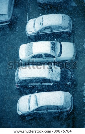 elevated view of snow covered cars in parking lot
